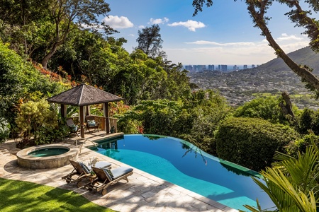 Resort-style pool with panoramic city views and a shaded cabana for relaxing in paradise.