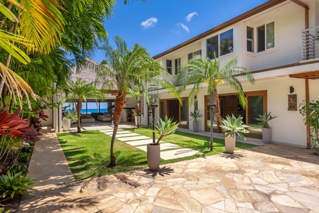 Unwind in your spacious living area where modern comfort meets breathtaking oceanfront views, perfect for gathering with loved ones as palm trees sway and the turquoise sea beckons just beyond your open doors.