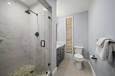 Full bathroom located in bedroom 2 has a walk-in shower, modern vanity, and soft natural light.