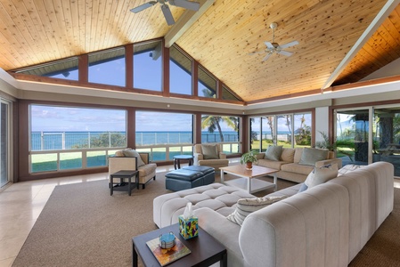 Bright and airy seating area framed by floor-to-ceiling windows and serene ocean scenery.