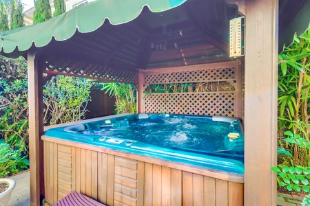 Private hot tub beneath a shaded pergola.