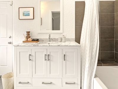 Refresh in your elegant marble-topped bathroom with modern amenities and stylish shower space.