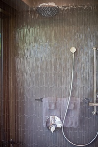 Wash away the beach day in this modern rainfall shower with soothing neutral tones.