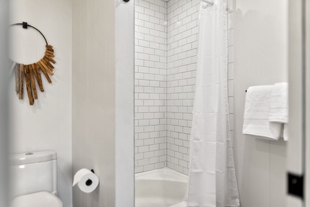 Bright shower space with classic subway tile, offering a refreshing place to rinse after a day at the beach.
