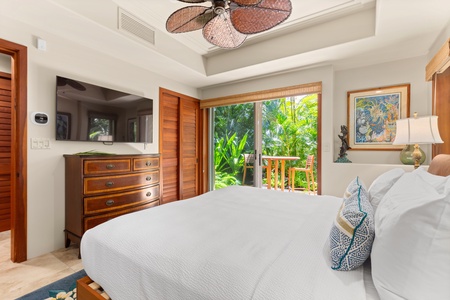 Guest bedroom with twin beds convertible to a king, overlooking tropical foliage.