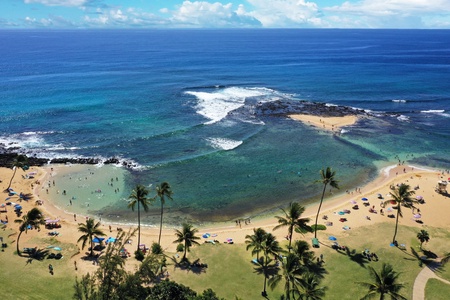 Aerial of turquoise shallows and palm-fringed coastline near Poipu.