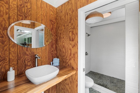 A wood-paneled bathroom tucked alongside the pool