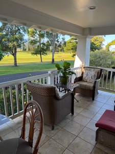 Outdoor patio with cozy seating and lush greenery views.