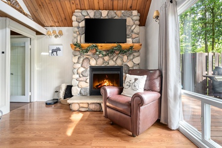 Enjoy a quiet moment by the stone fireplace, a perfect spot for reading or sipping your morning coffee.