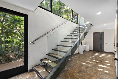 Floating glass staircase enhances the home's contemporary architectural design.