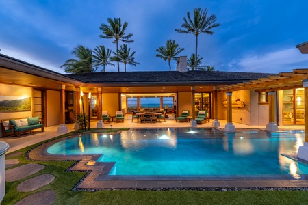 Pool courtyard with evening glow and ocean backdrop.