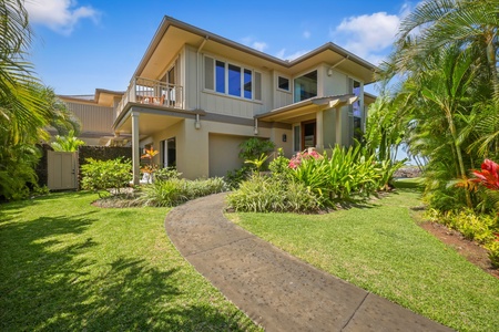 Tropical landscaping lines the front entrance of this exquisite split level villa.