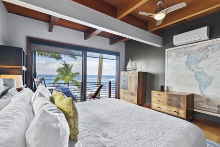Modern bedroom with a king-size bed and a private balcony overlooking the sea.