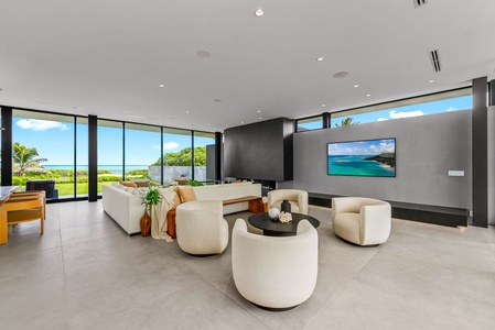 Unwind in a bright gathering space where floor-to-ceiling glass frames the ocean beyond.
