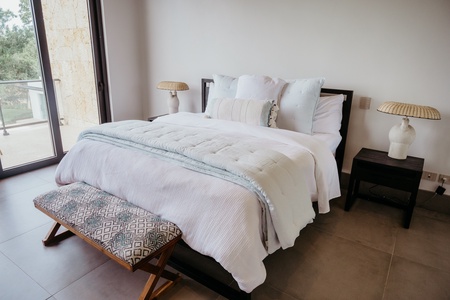 Comfortable bed and modern decor in the guest bedroom with private patio.