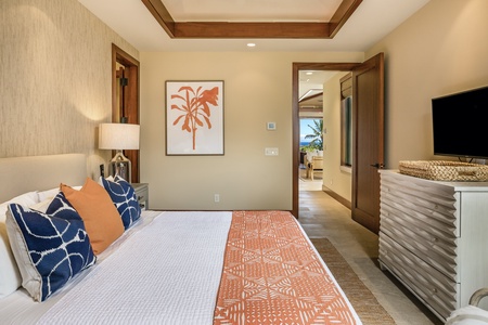 Reverse view of guest bedroom one featuring king-sized bed and flat screen TV.