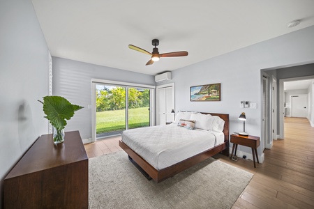 Bedroom 2 with queen bed, closet, dresser, and access to the garden via sliding glass doors.