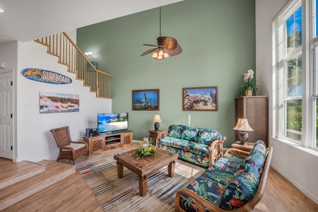 Living Room w Flatscreen TV, Two Sofas and Open Staircase to Upstairs Bedrooms.