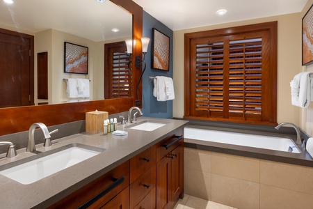 Unwind in your spacious bathroom with dual vanities, soaking tub, and elegant wood finishes creating a spa-like retreat.