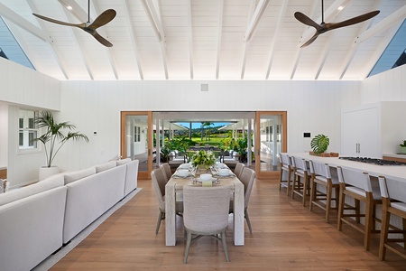 Elegant dining space with vaulted ceiling and lush views.