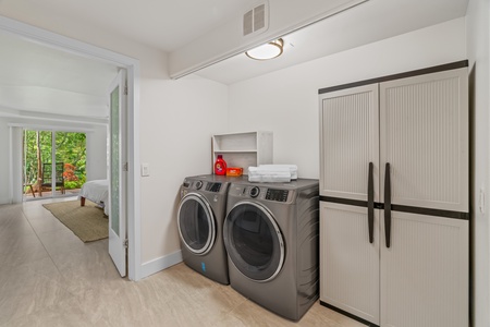 Full laundry room with high-efficiency washer, dryer, and second fridge.