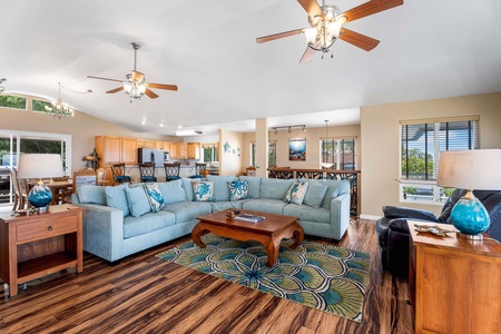 The living area has plush sectional sofas, ceiling fan and TV.