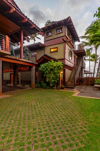 Spacious driveway with lush green landscaping leading to the property.