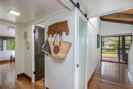 Modern barn door adds a sleek, island-chic touch to this stylish hallway space.