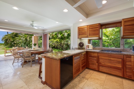 Your gorgeous kitchen opens to lush gardens, featuring granite counters and rich wood cabinetry for seamless indoor-outdoor cooking.