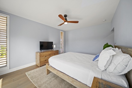 Alternate view of the queen suite shows Smart TV and dresser storage.