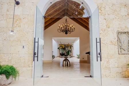 The villa's entrance hall featuring a chandelier and a striking floral arrangement.