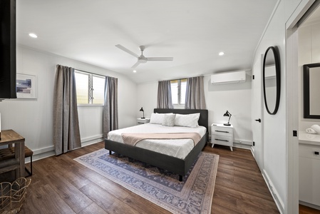 Minimalist suite with a king-sized bed, serene design, and large windows for natural light and breezy comfort.