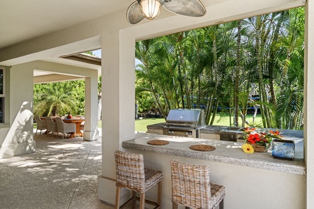 Shaded patio dining area with lush landscaping, offering a serene space for meals.