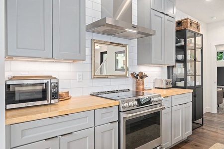 Whip up meals with ease in this fully stocked kitchen featuring an induction range and custom cabinets.