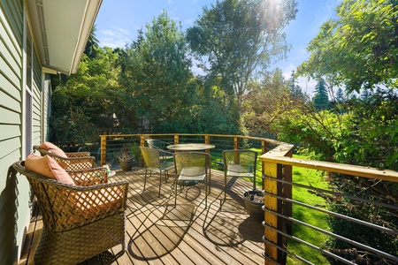 Relax on the Geneva Retreat's deck, perfect for enjoying a morning coffee surrounded by lush greenery.