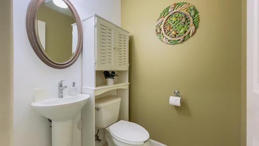 Main-level powder room offers added convenience with charming wall art and thoughtful finishes for your stay.