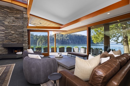 Cozy living room with floor-to-ceiling windows and breathtaking water views.