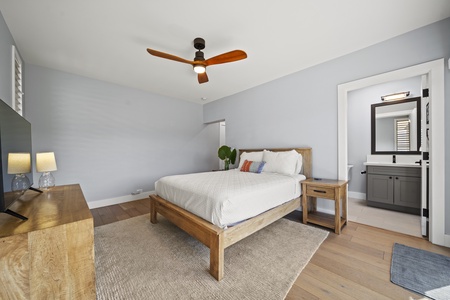 Bedroom 3 featuring a queen-sized bed, dresser, and simple wood accents.