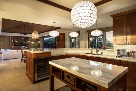 Spacious modern kitchen with gleaming quartzite countertops, capiz shell backsplash & a circular, open flow
