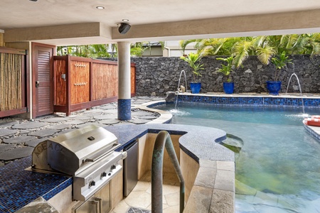 Outdoor BBQ station with built-in grill and shaded prep area—perfect for poolside grilling and family feasts.