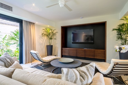Unwind in this cozy entertainment room, featuring a modern flat-screen TV and comfortable seating.