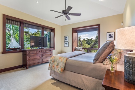 Second bedroom with king-size bed, window seat, and large flat-screen TV.