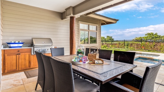 Outdoor dining set for eight with view of built-in barbecue grill.