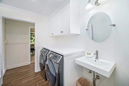 The laundry room is equipped with a washer, dryer, and iron