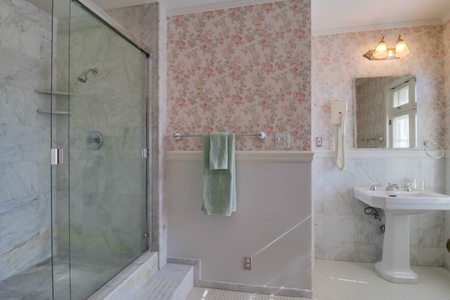 Ensuite bath with walk-in shower and historic tile accents.