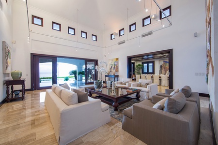 Spacious living space with ample seating, high ceiling, and seamless access to the dining area and outdoor views.