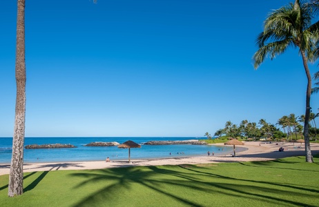 Green grasses, sandy beaches, thatched umbrellas and a drink.