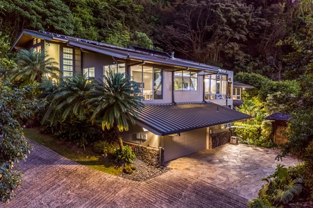 Lower-level exterior showcasing the estate’s tiered design and lush, gated surroundings.