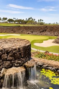 Curved lava rock walls trace the edge of world-class greens with natural elegance.