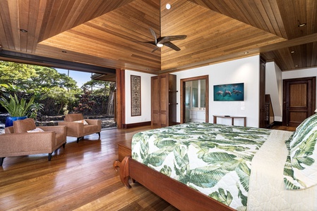 Wake up in your tropical sanctuary where warm wood and palm-print linens create perfect harmony with lush garden views beyond.